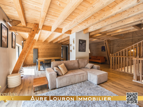 Intérieur d'un chalet de prestige rénové avec un salon spacieux et des poutres en bois.