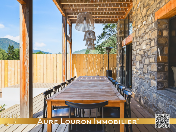 Terrasse d'un chalet de prestige à Guchan avec une grande table en bois et des chaises noires.
