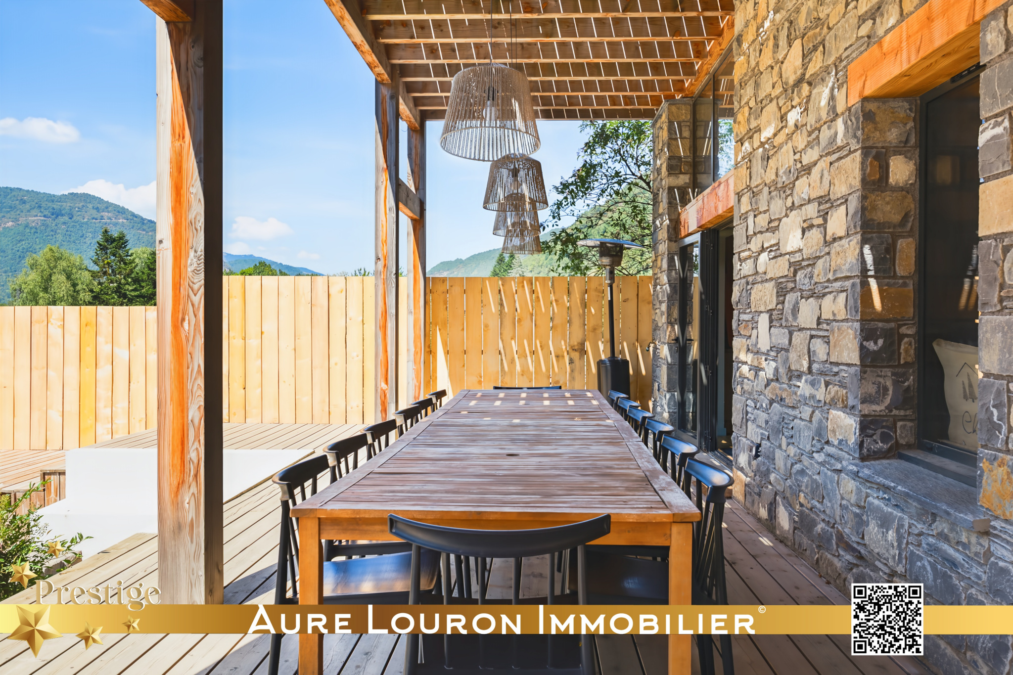 Terrasse du chalet de prestige à Guchan Terrasse d'un chalet de prestige à Guchan avec une grande table en bois et des chaises noires.
