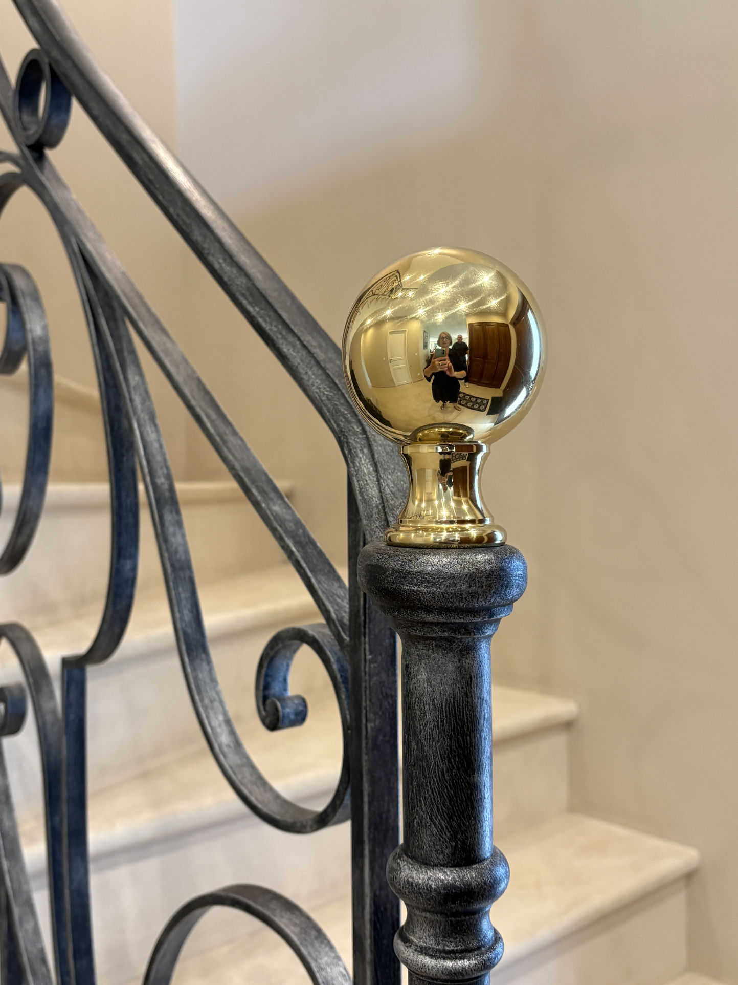 Détails d’un escalier élégant Garde-corps en métal avec une boule dorée au sommet, escalier en marbre en arrière-plan.