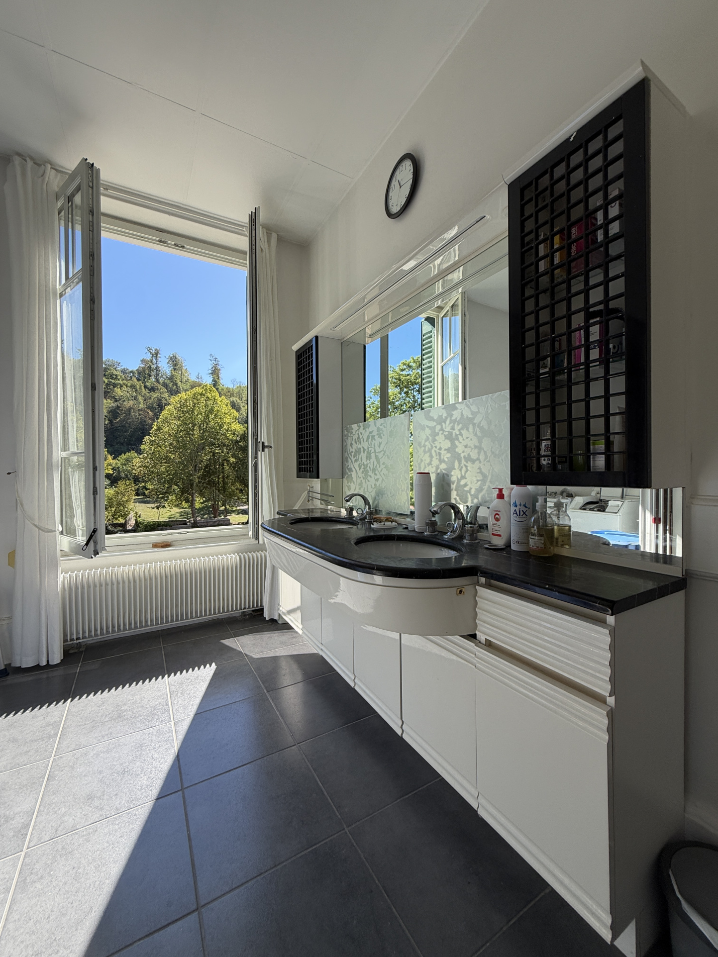 Bathroom with a view Bright bathroom with garden view, windows open.