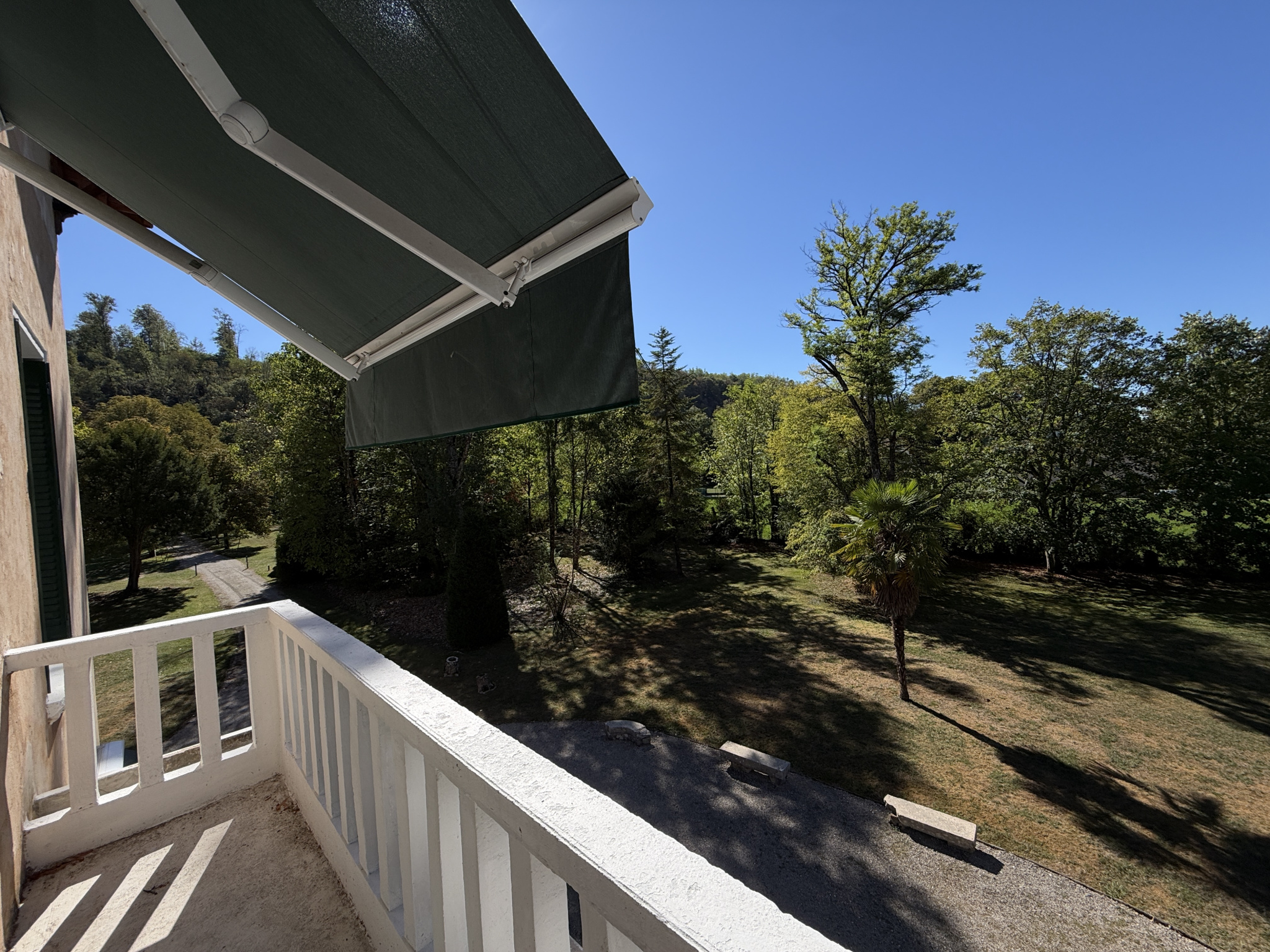 Property on the banks of the Ain river View from a balcony overlooking a wooded park and the Ain river in Neuville-sur-Ain.