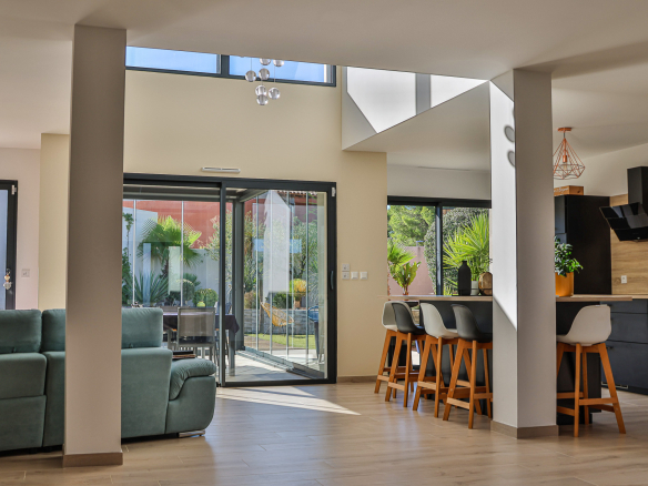 Interior of a contemporary villa with a bright living room, modern kitchen and access to the terrace.