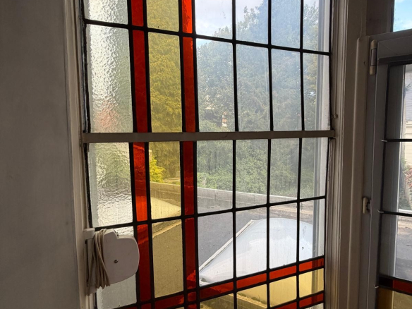 Colourful stained glass window in a mansion in Lille, with a view of the outside.