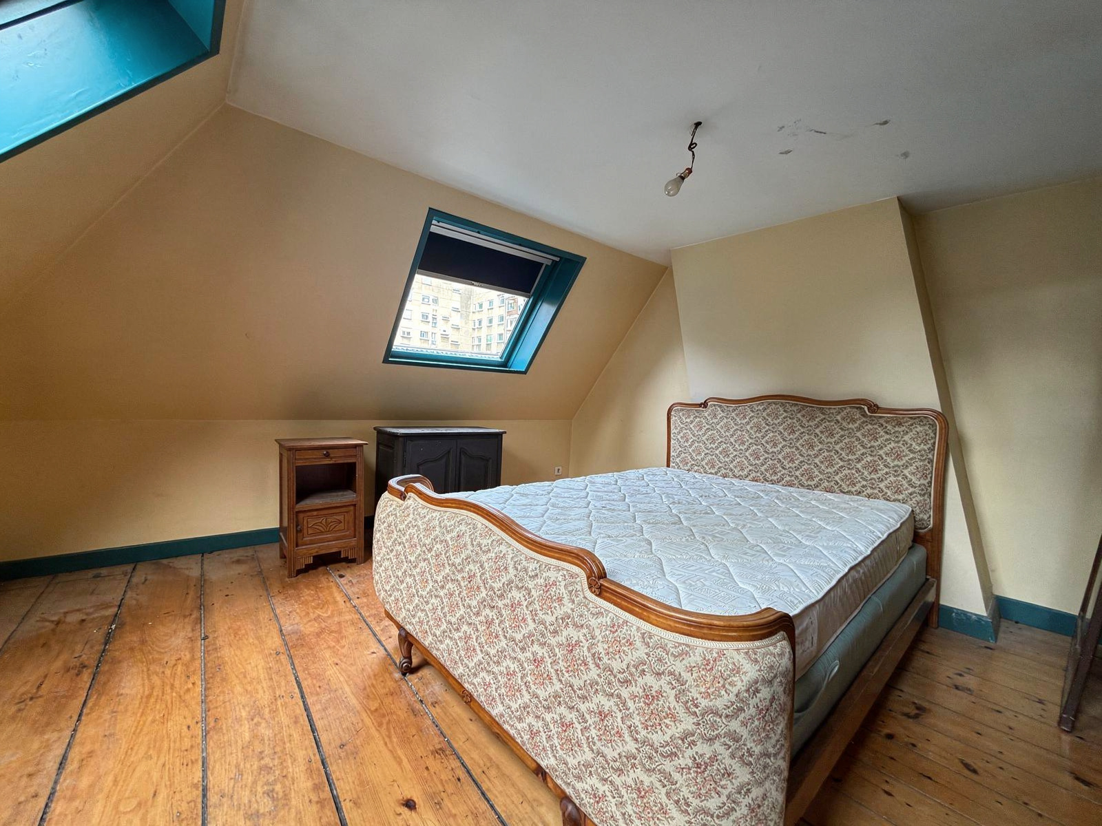 Room in a mansion in Lille Bedroom in a manor house with bed and wooden parquet floor, skylight.