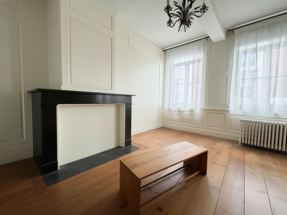 Interior of a mansion in Lille, with marble fireplace and wooden parquet flooring.