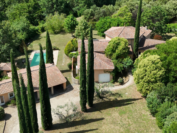 Aerial view of a Provençal villa with swimming pool and wooded gardens in Saint-Romain-en-Viennois.