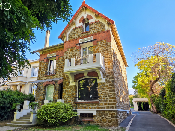 Stone and brick millstone house in Arpajon, with landscaped garden and visible entrance.