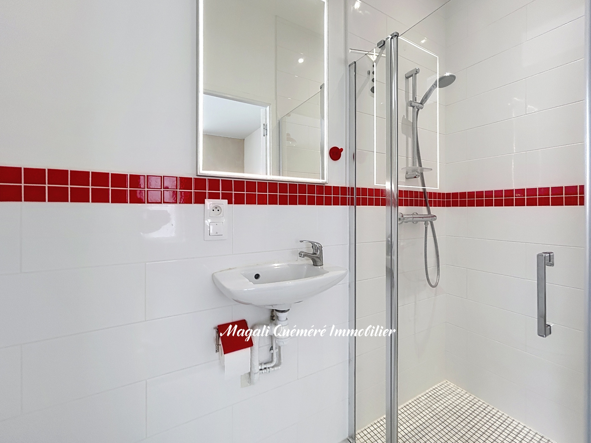 Salle de bain rénovée Salle de bain moderne avec douche et lavabo, carrelage blanc et rouge.