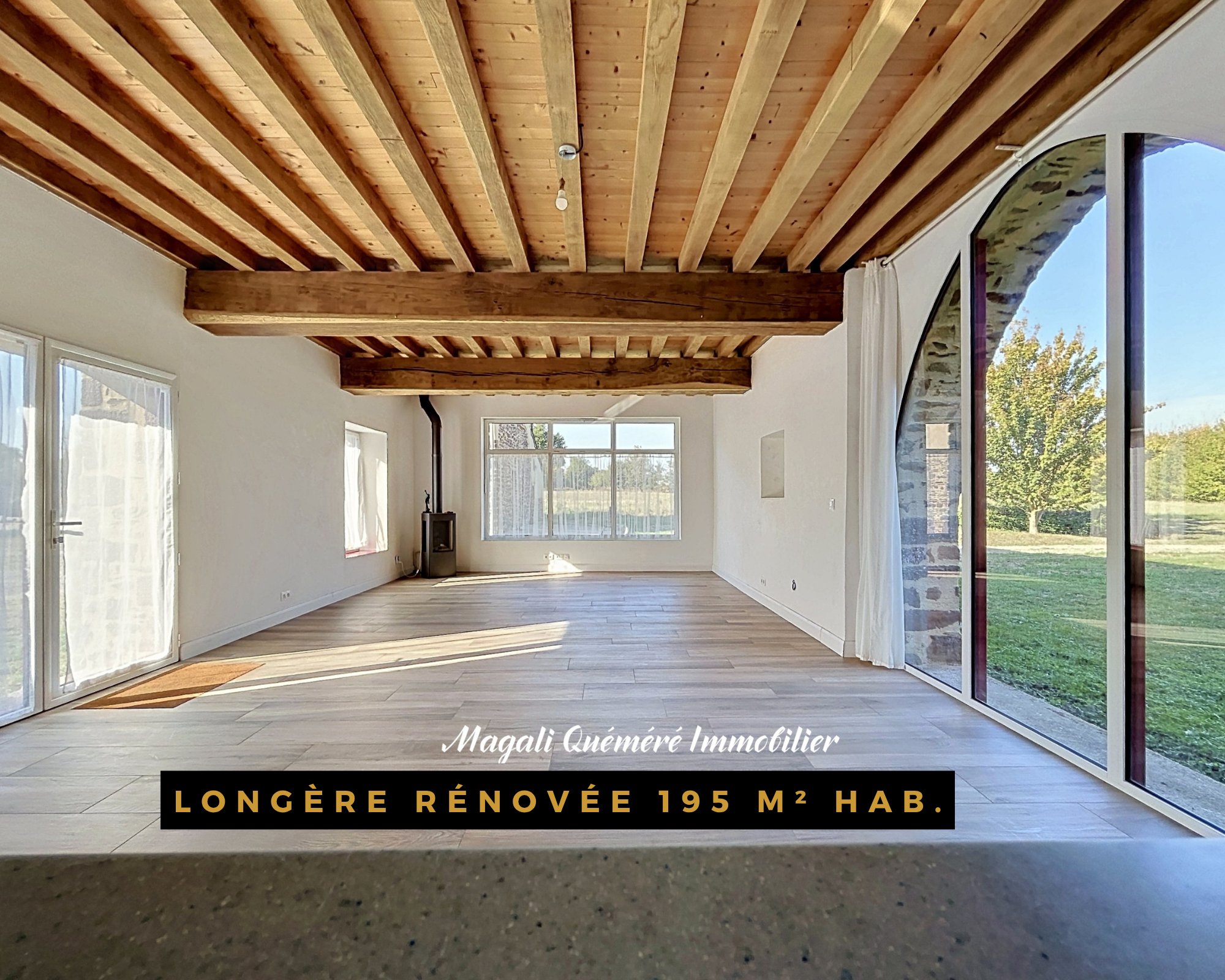Intérieur d’une longère rénovée Intérieur d'une longère rénovée de 195 m² avec poutres apparentes et grandes fenêtres.