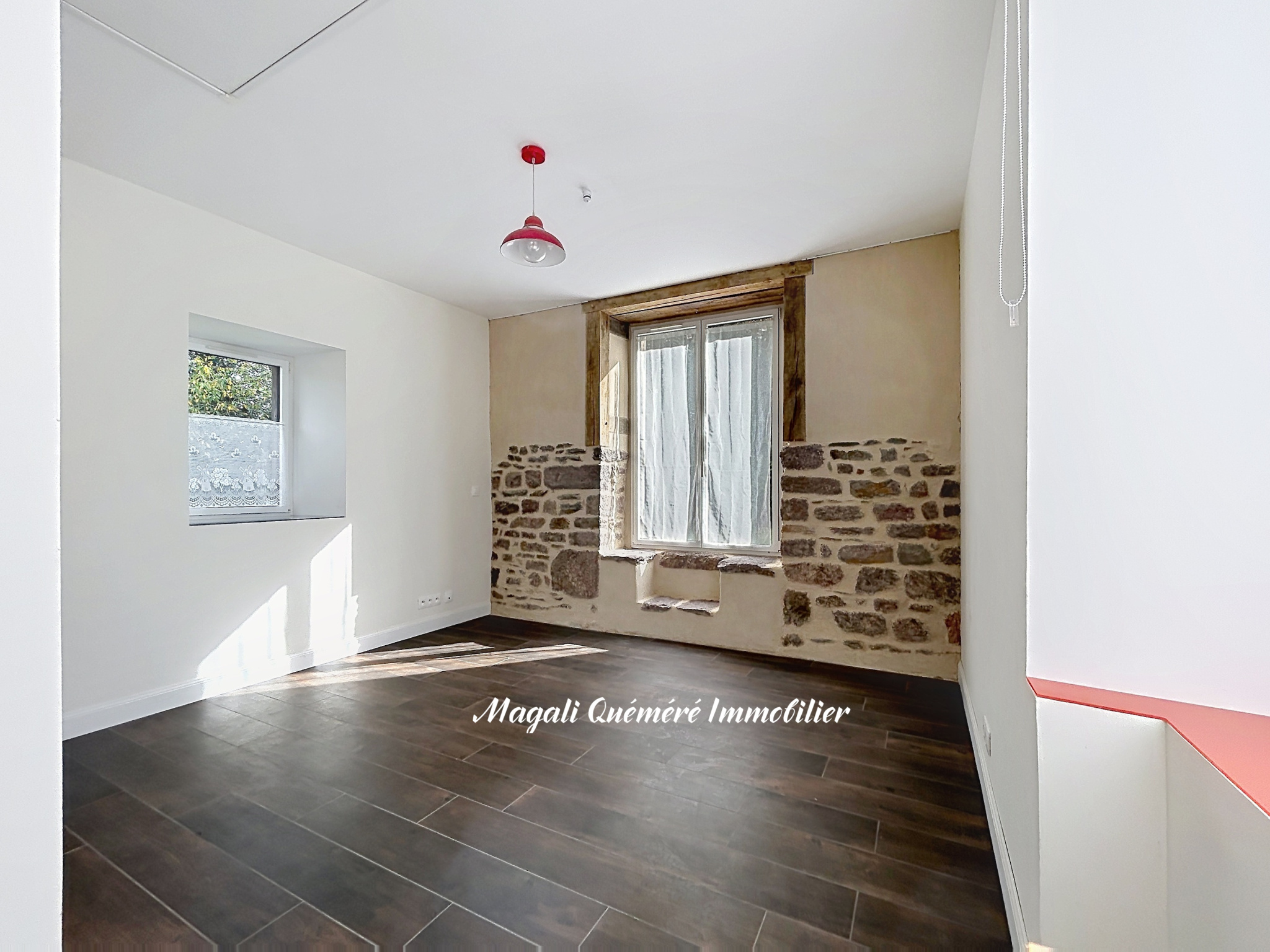 Intérieur rénové d’une propriété à Montfort-sur-Meu Intérieur d'une pièce rénovée avec murs en pierre et fenêtre sur Montfort-sur-Meu.