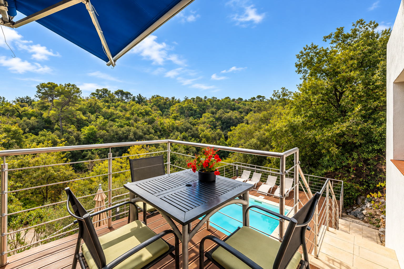 Terrasse avec vue sur piscine à Saint-Jeannet Terrasse avec table et chaises surplombant une piscine et une végétation luxuriante à Saint-Jeannet.