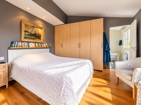 Chambre d'une villa avec lit double, meubles en bois et lumière naturelle à Saint-Jeannet.