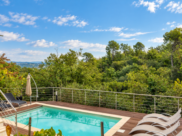 Vue d'une villa avec piscine et terrasse entourée de verdure à Saint-Jeannet.