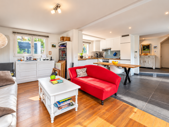 Intérieur d'une villa moderne avec salon, cuisine ouverte et coin repas.