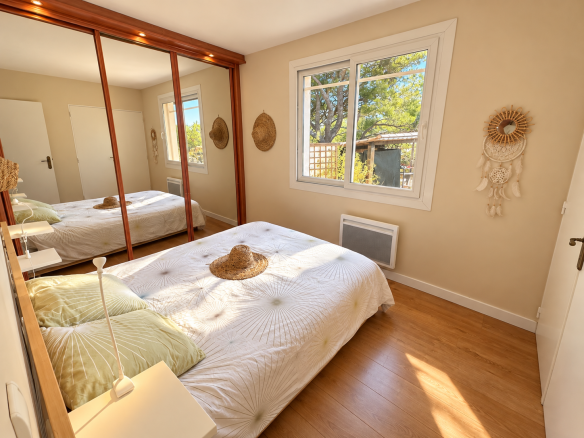 Chambre lumineuse avec lit et décor naturel dans une villa à Ensuès-la-Redonne.