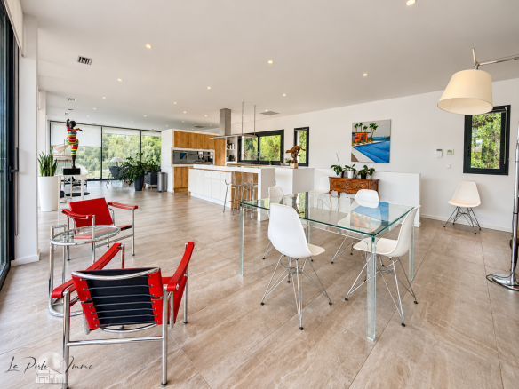 Intérieur d'une villa moderne avec salon lumineux et mobilier contemporain.