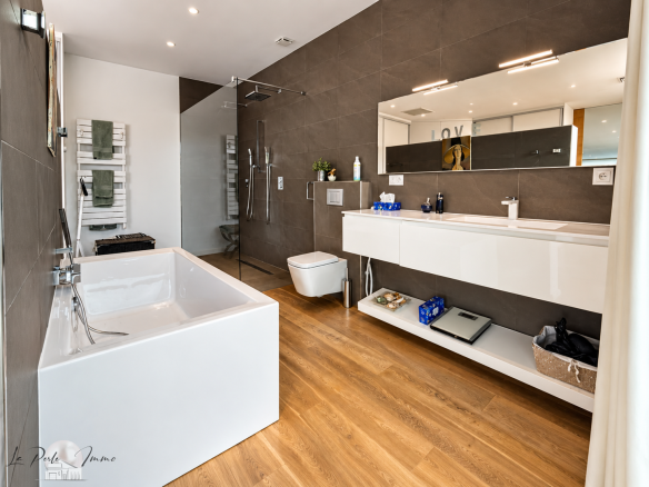 Salle de bain moderne avec baignoire et meuble vasque dans une villa contemporaine.