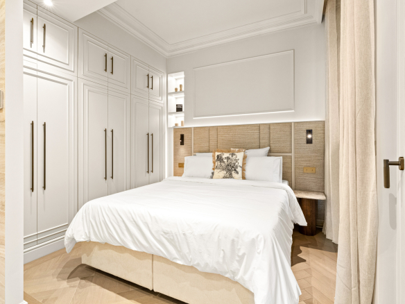 Room in a renovated apartment with a double bed and built-in storage.