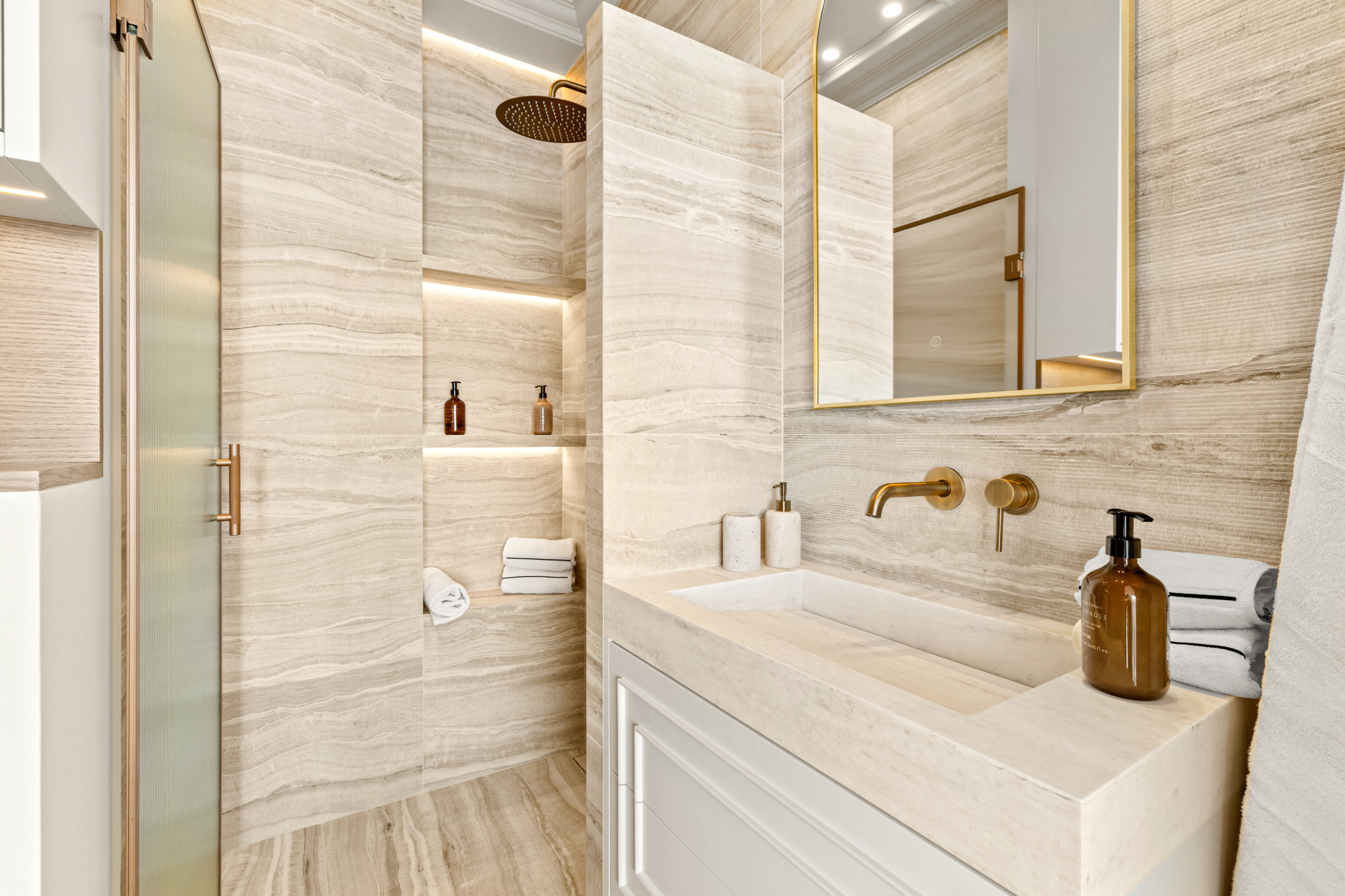 Modern bathroom Modern bathroom with stone walls and gold fixtures, soft lighting.