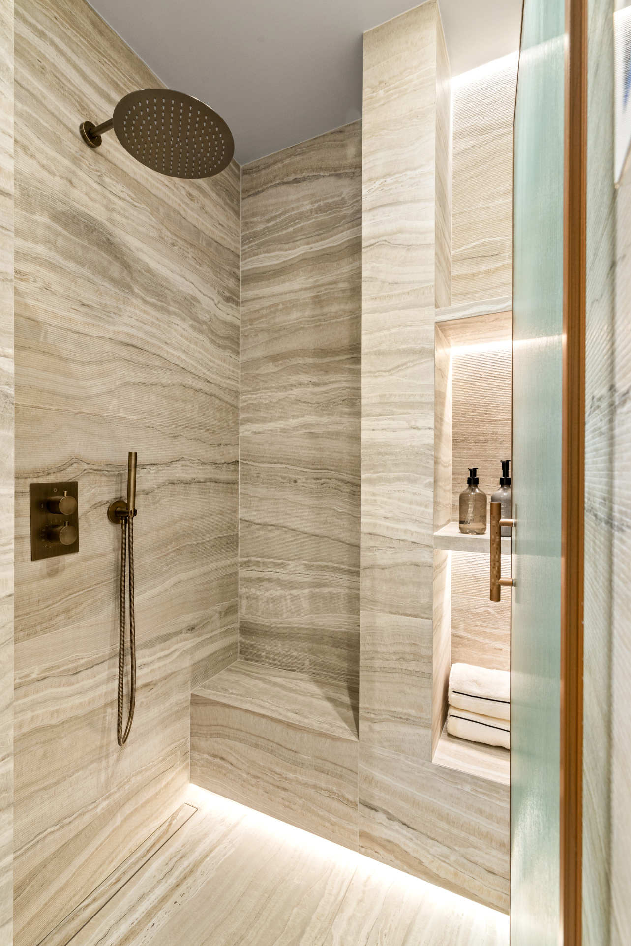 Contemporary bathroom Modern bathroom with beige stone shower and integrated lighting.