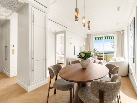 Interior of a renovated apartment with sea view in Nice, round table and modern decor.