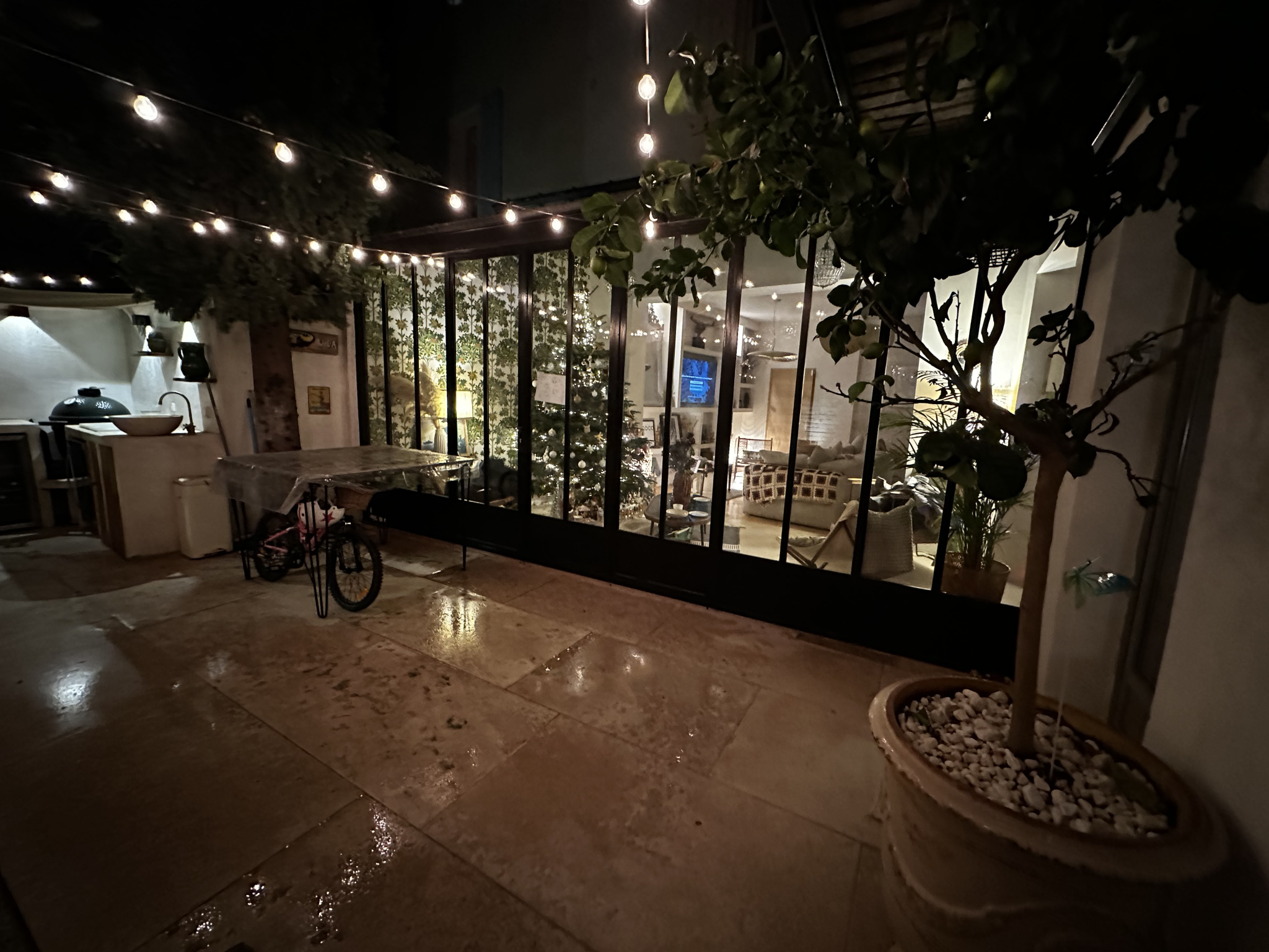 Intérieur d’une maison de village Intérieur d'une maison de village rénovée avec un patio et des lumières suspendues.