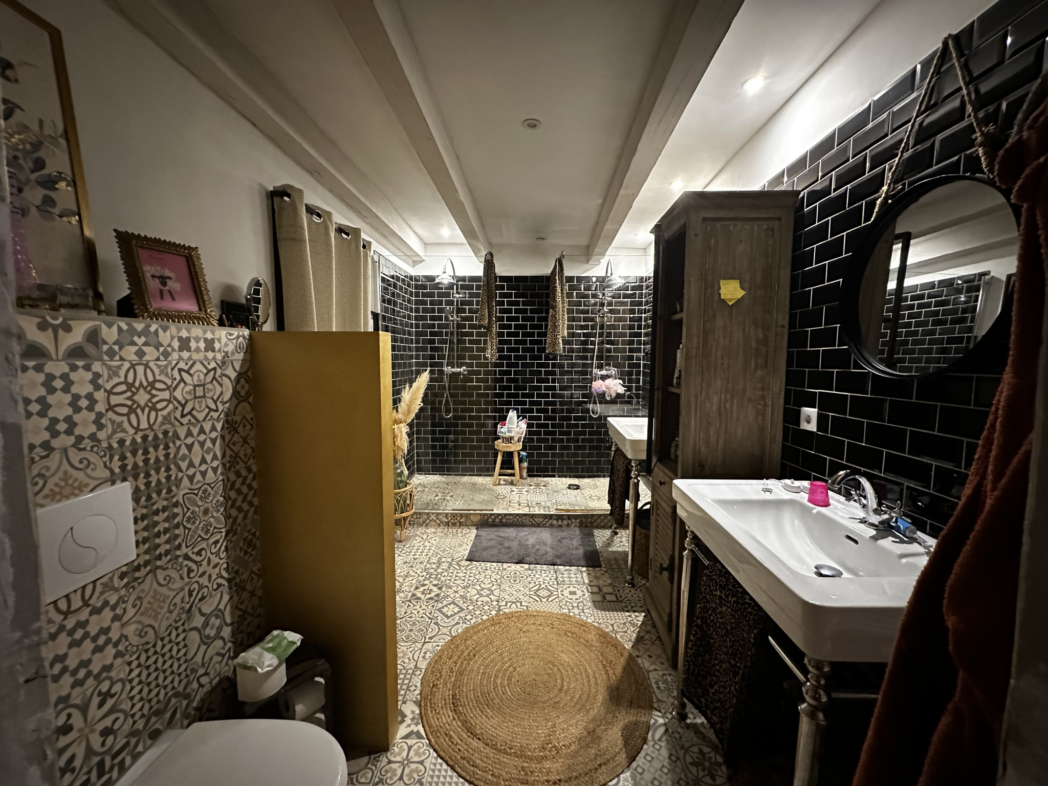 Salle de bain rénovée Salle de bain spacieuse avec carrelage noir et décorations élégantes.
