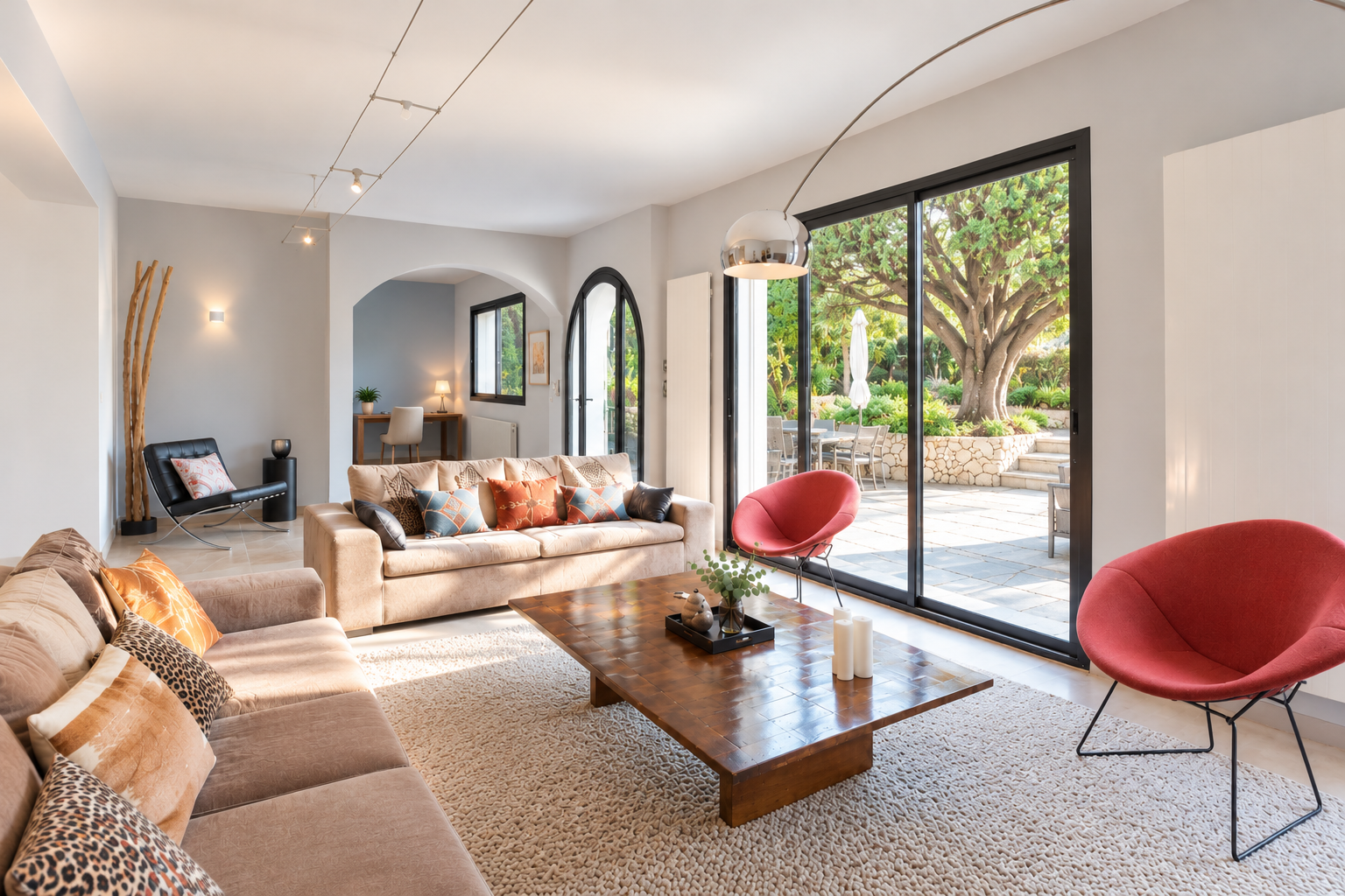Interior of a modern house with a bright living room, comfortable sofas and a large bay window overlooking the garden.