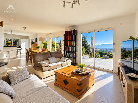 Intérieur d'une maison avec vue sur le Mont-Blanc, salon lumineux et décor moderne.
