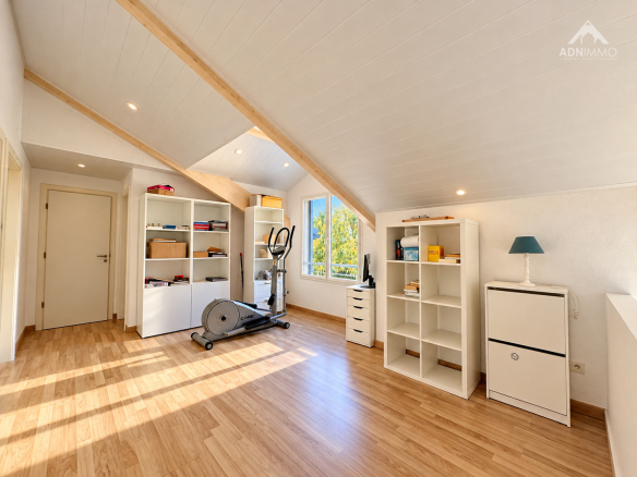 Intérieur lumineux d'une maison avec espace de travail et équipements de fitness.
