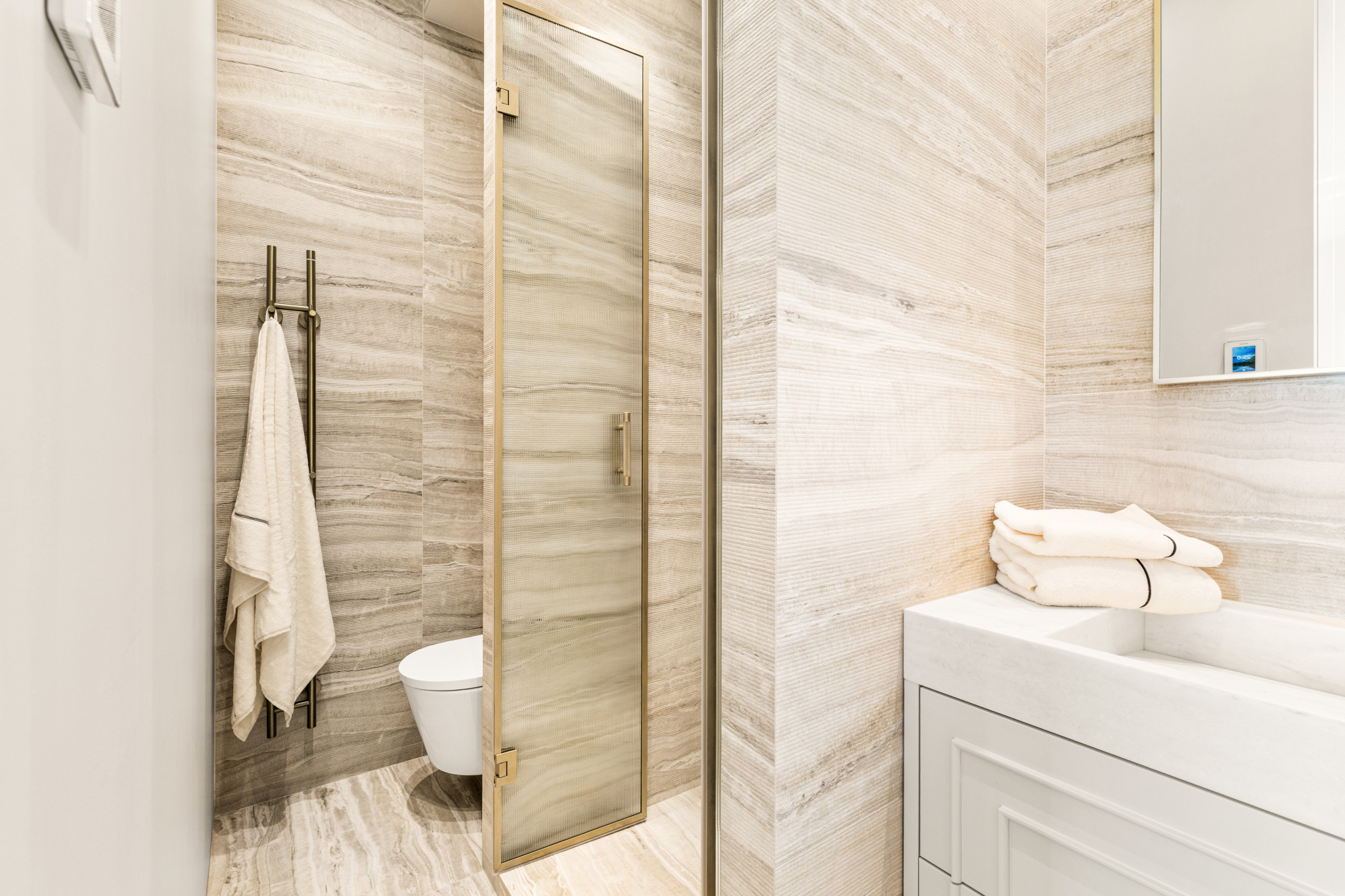 Salle de bain rénovée Salle de bain moderne avec douche en verre et carrelage beige.