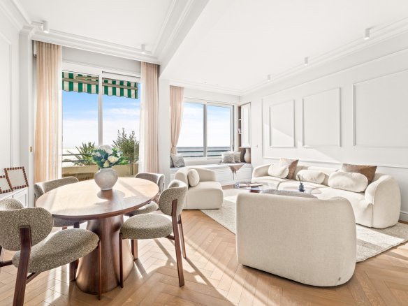 Intérieur d'un appartement rénové avec vue sur la mer à Nice, mobilier moderne et lumineux.