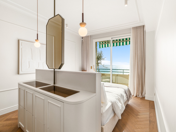 Chambre d'un appartement rénové avec vue sur la mer à Nice, balcon et décoration moderne.