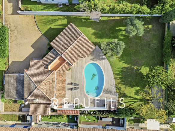 Vue aérienne d'une villa provençale avec piscine et terrain arboré à Lunel.