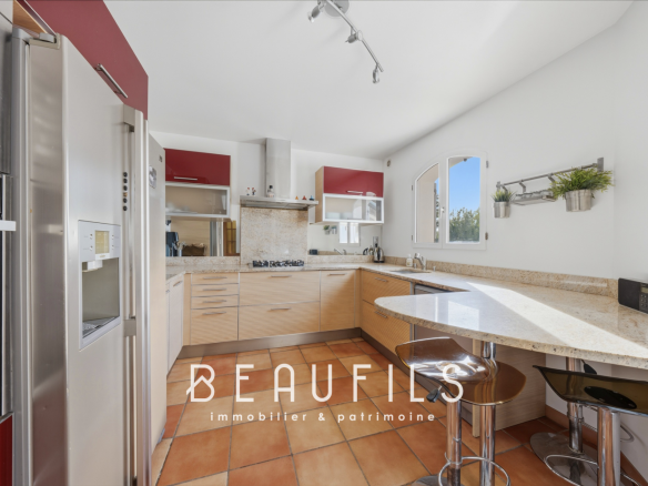 Cuisine moderne avec îlot central et équipements intégrés dans une villa provençale.