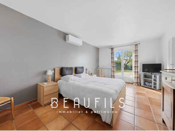 Chambre d'une villa provençale à Lunel, avec lit double et accès à l'extérieur.