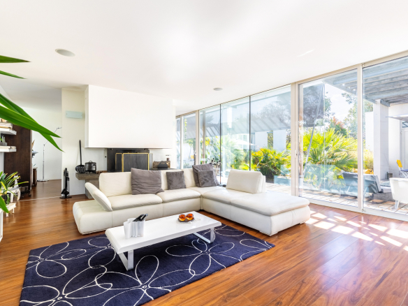 Intérieur d'une maison d'architecte moderne avec un salon lumineux et des baies vitrées donnant sur le jardin.
