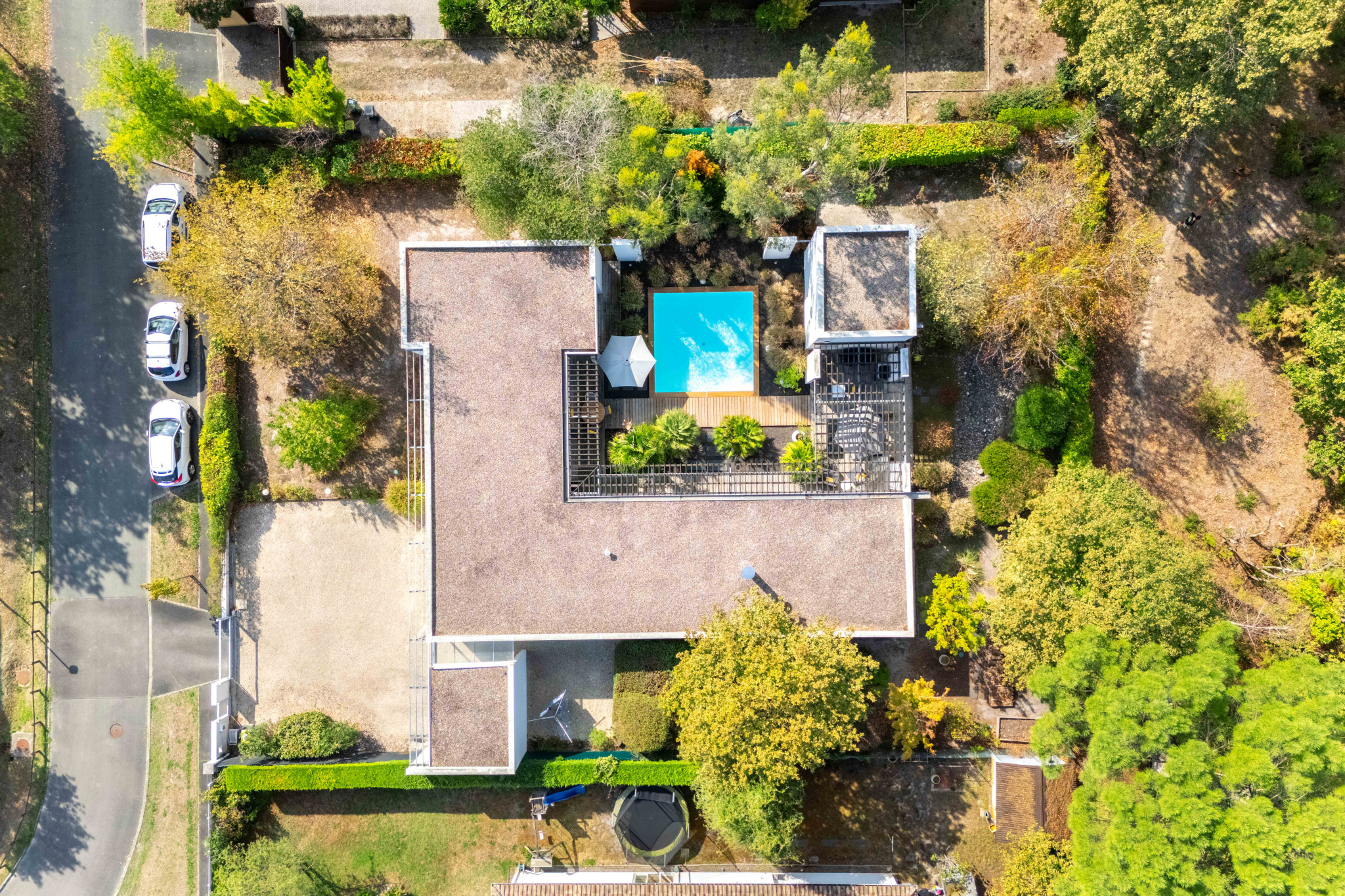 Maison d’architecte au Taillan-Médoc Vue aérienne d'une maison d'architecte de plain-pied avec piscine, jardin paysager et forêt environnante.