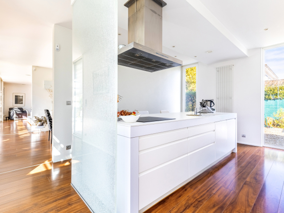 Intérieur d'une maison d'architecte moderne avec cuisine ouverte et lumière naturelle.