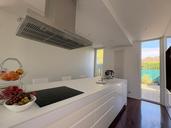 Cuisine moderne et lumineuse d'une maison d'architecte, avec vue sur le jardin.