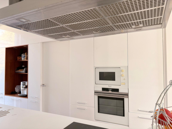 Cuisine moderne avec des meubles blancs et des appareils intégrés.