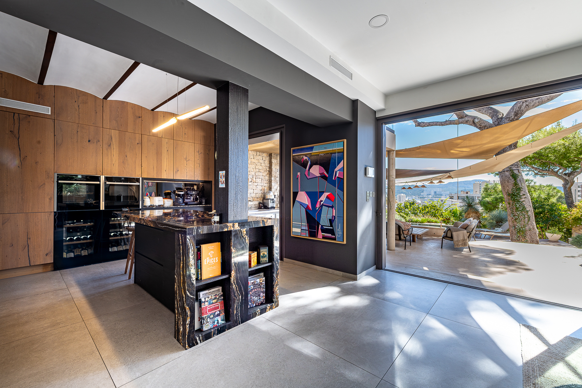 Intérieur d'une maison rénovée avec cuisine moderne et vue sur jardin à Marseille.