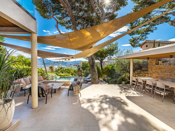 Terrasse d'une maison rénovée avec piscine et vue dégagée à Marseille, entourée de verdure.