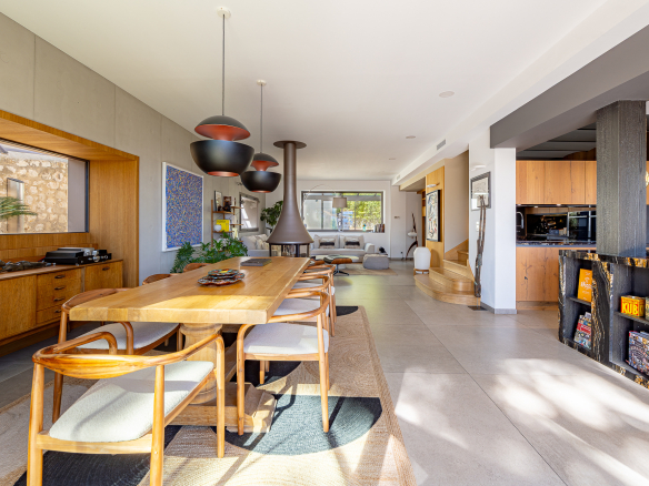 Intérieur d'une maison rénovée avec salle à manger, cuisine moderne et cheminée.