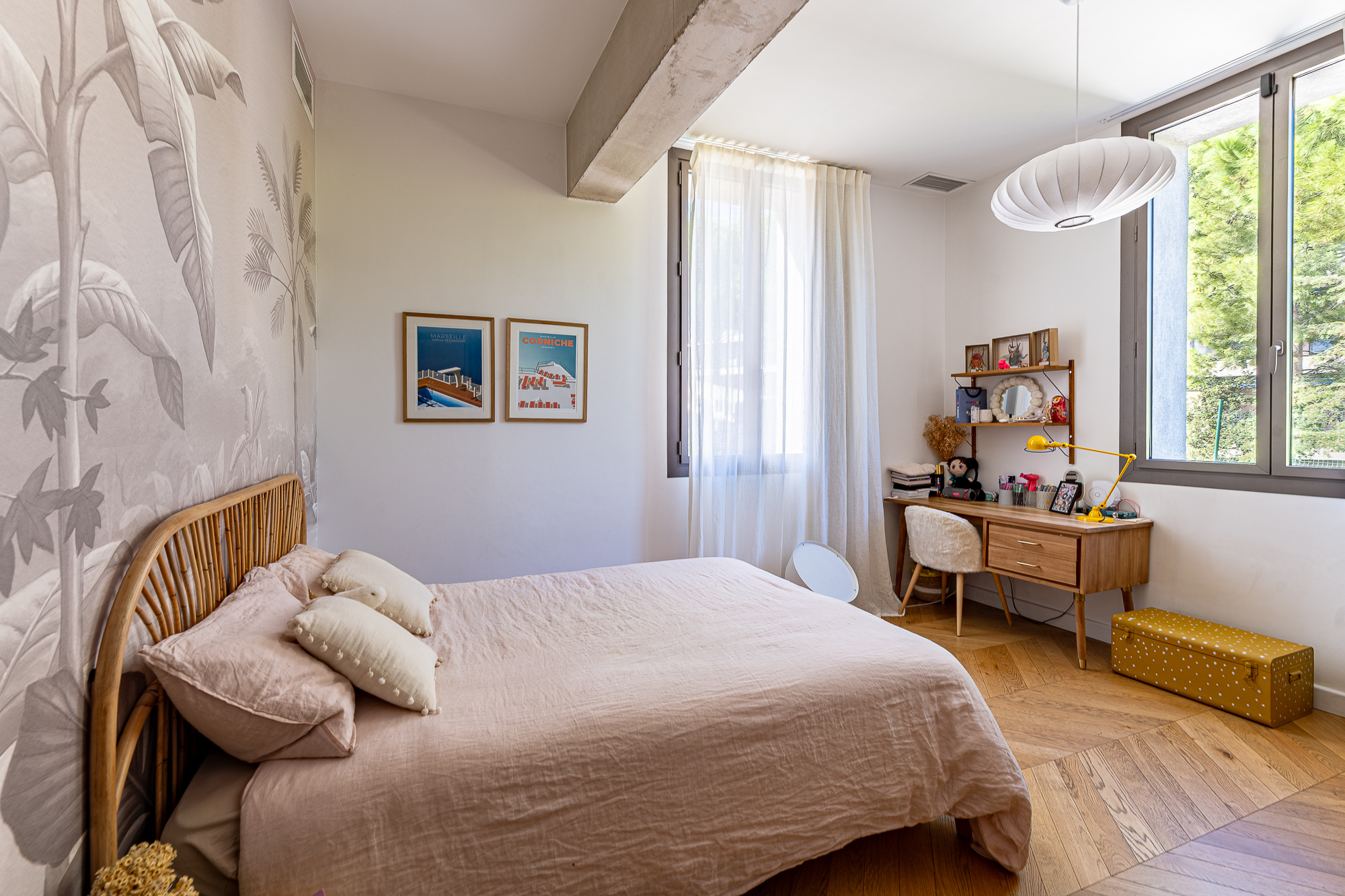 Chambre d'une maison rénovée avec un lit, un bureau et des fenêtres lumineuses.