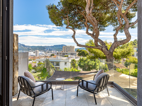 Terrasse avec fauteuils et vue dégagée sur Marseille et les collines environnantes.