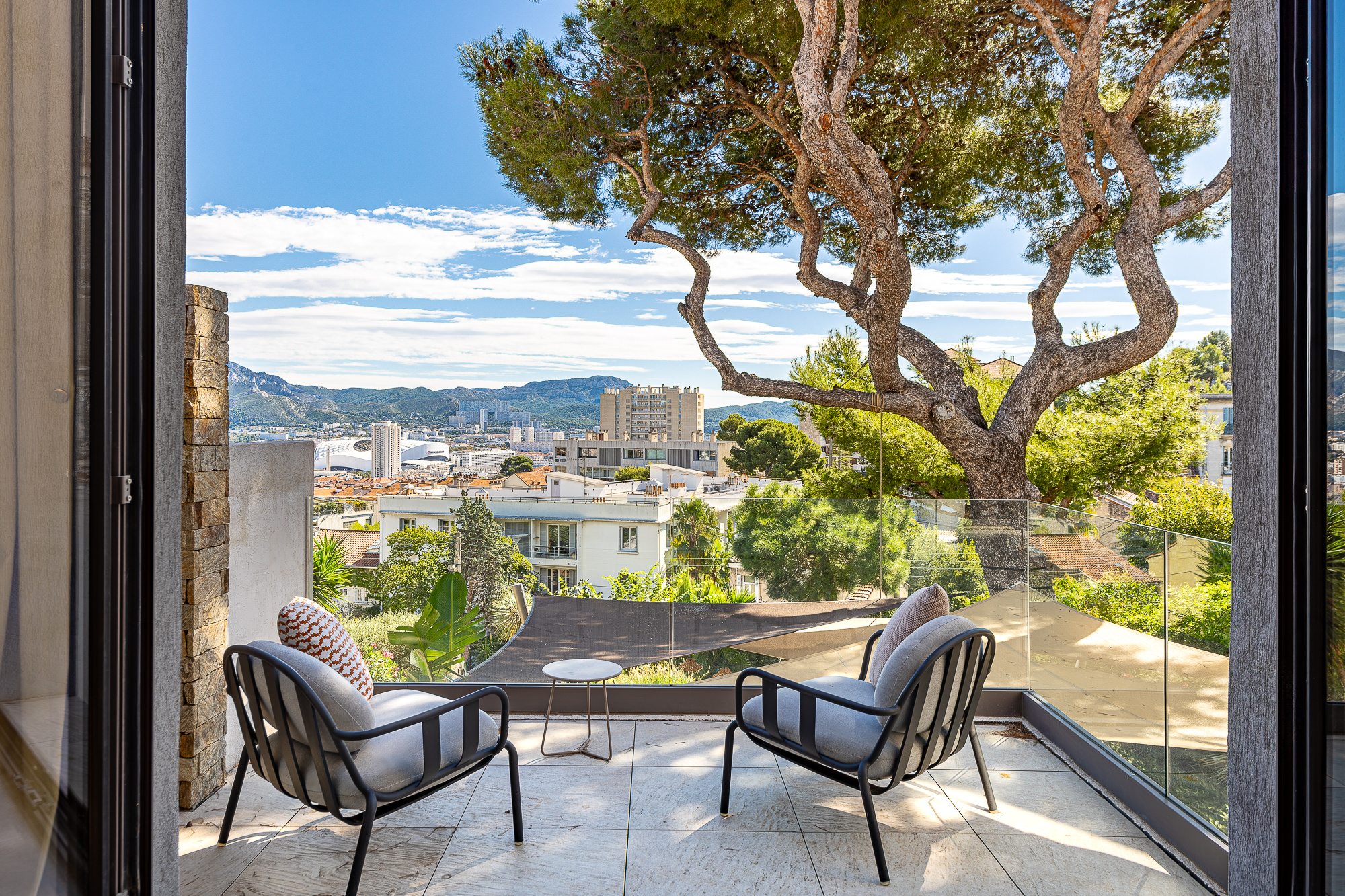 Terrasse avec fauteuils et vue dégagée sur Marseille et les collines environnantes.