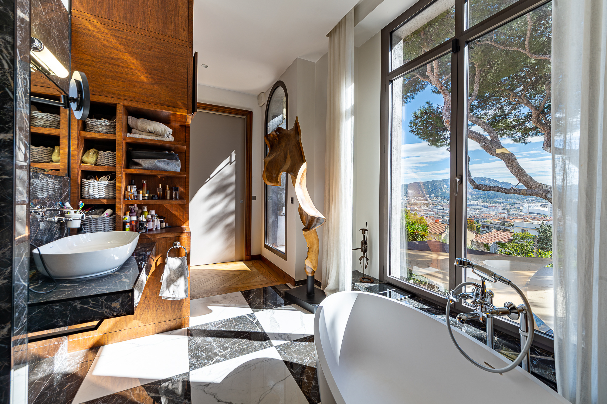 Salle de bain moderne avec vue dégagée sur Marseille, baignoire et décoration contemporaine.