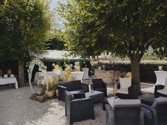 Outdoor space of a property with armchairs and festive decoration, surrounded by trees.